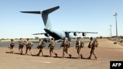 Des soldats français de l'opération Barkhane passant devant un Airbus A-400 M Atlas de l'armée de l'air française à la base militaire française de Tombouctou, au Mali, le 5 décembre 2021, pour lutter contre les jihadistes qui s'étendent au Sahel. (Photo A