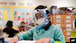 Seorang siswa menggunakan masker dan pelindung wajah saat menghadiri kegiatan belajar di Sekolah Dasar Washington di Lynwood, California, pada 12 Januari 2022. (Foto: AP/Marcio Jose Sanchez)