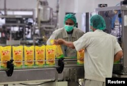 Sejumlah karyawan mengemas minyak goreng kemasan untuk dikirim di sebuah gudang milik Sinar Mas Agro Resources and Technology (SMART) di Marunda, Jawa Barat, 3 Mei 2012.(Foto: Reuters/Arsip)