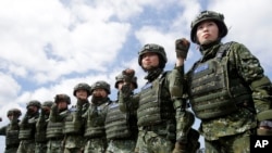 FILE - The first team of Taiwan artillerywomen poses for the press during the annual Han Kuang exercises in Pingtung County, Southern Taiwan, May 30, 2019. The U.S. approved the sale of $2.2 billion worth of military equipment to Taiwan, July 9, 2019.