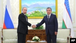 Uzbekistan's Prime Minister Shavkat Mirziyayev, right, poses for a photo with Russian President Vladimir Putin in Samarkand, Uzbekistan, Sept. 6, 2016. Putin came to offer condolences and visit the grave of Uzbekistan's late president, Islam Karimov.