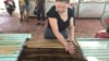 A woman works making candy in Ben Tre, Vietnam, where some say workplaces should embrace traits traditionally seen as feminine, such as humility.