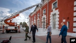 Gubernur Kursk Roman Starovoit (kedua dari kanan) memperhatikan lokasi serangan drone Ukraina di sebuah stasiun kereta api di Kursk, Rusia, 20 Agustus 2023. (Foto: Telegram Gubernur Kursk Roman Starovoit via AP)