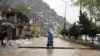 Seorang perempuanAfghanistan berjalan melewati air banjir saat hujan deras turun di Kabul, Afghanistan, Selasa, 16 April 2019. (Foto: AP)