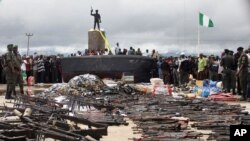 Policemen display weapons collected from Niger delta militants as part of a government amnesty program in Yenagoa, Nigeria, August 22, 2009.