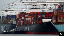 The Yang Ming shipping line container ship Ym Utmost is unloaded at the Port of Oakland on Monday, July 2, 2018, in Oakland, Calif. The Trump administration on Friday, July 6, 2018, will start imposing tariffs on $34 billion in Chinese imports.
