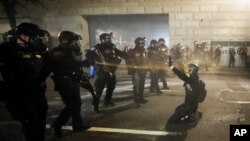 Demonstrators huddle and blow back tear gas with leaf blowers during clashes with federal officers during a police brutality protest at the Mark O. Hatfield United States Courthouse July 29, 2020, in Portland, Ore.