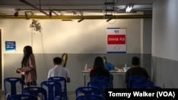 A medical worker provides a COVID-19 testing kit to patients at the Thonburi Bamrungmaung Hospital, Bangkok, Thailand, Feb 24. 2022. (Tommy Walker / VOA)