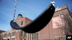 FILE - A swing sits empty on a playground outside in Providence, R.I., March 7, 2020.