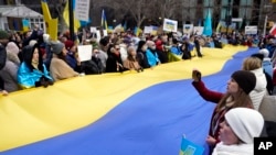 FILE: Pro-Ukraine demonstrators unfurl a large Ukraine flag in a park in New York across the street from the United Nations, Feb. 24, 2022. 