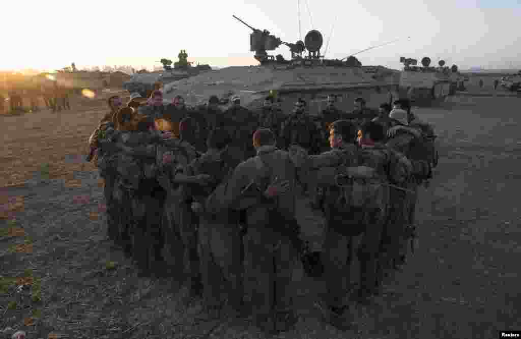 Israeli soldiers from the Golani Brigade stand in a circle at a staging area before entering Gaza from Israel, July 30, 2014.&nbsp;