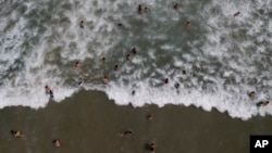 La gente nada en la playa de Los Ángeles después de que reabrió tras un cierre para contener la propagación del COVID-19 en La Guaira, Venezuela. el 23 de octubre de 2020.