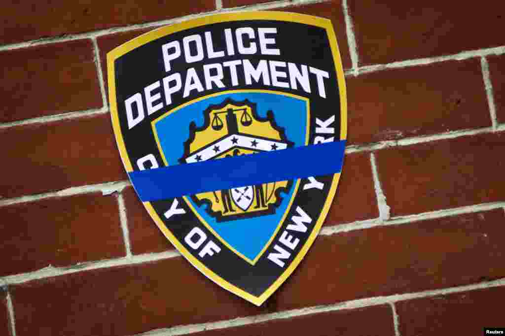 An NYPD logo is pictured on wall above makeshift memorial at the site where two police officers were shot in the head in the Brooklyn borough of New York, Dec. 22, 2014.