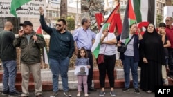 A young Palestinian girl holds up a portrait of slain Hamas leader Yahya Sinwar during a rally in Ramallah, in the occupied-West Bank on Oct. 18, 2024.