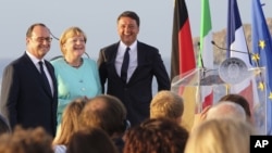 ARSIP - PM Italia Matteo Renzi (kanan), Presiden Perancis Francois Hollande (kiri), dan Kanselir Jerman Angela Merkel berdiri di dek kapal induk Itlia Garibaldi di lepas pantai pulau Ventotene (22/8/2016). (foto: AP Photo/Roberta Basile)