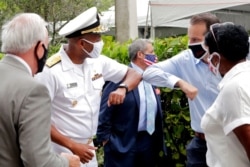 FILE - Surgeon General Dr. Jerome Adams, left, bumps elbows at Sergio's Restaurant in Doral, Florida, July 23, 2020.