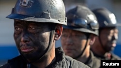 FILE - Miners wait in lines to shower during a break near a coal mine in Heshun county, Shanxi province.