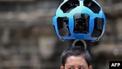 A Cambodian technician carries a back-pack mounted with a device housing 15 cameras as he demonstrates the technique used to digitally map the Angkor Wat temple, part of the Angkor architectural complex in north-western Cambodia on April 3, 2014. 