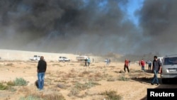 Black smoke billows from a warehouse after an airstrike in Zawura, west of Triploi, Libya, Dec. 2, 2014.
