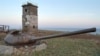 FILE - In this undated photo, a turret from an old tank set in the ground as a part of war fortifications in front of a lighthouse near Yuzhno-Kurilsk on Kunashiri Island, one of the Kuril Chain, known as the Northern Territories in Japan.