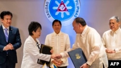 Japan's Foreign Minister Yoko Kamikawa and Philippine Defense Minister Gilberto Teodoro shake hands after signing the Reciprocal Access Agreement at the Malacanang Palace in Manila on July 8, 2024.