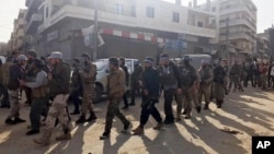 Turkey-backed Free Syrian Army soldiers walk in city center of Afrin, northwestern Syria, March 18, 2018. 
