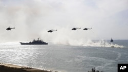 FILE - Russian navy ships and helicopters take a part in a landing operation during military drills at Crimea's Black Sea coast, Sept. 9, 2016.