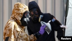 FILE - Forensic investigators work near a home where two people were poisoned with the nerve-agent Novichok, in Amesbury, Britain, July 6, 2018.