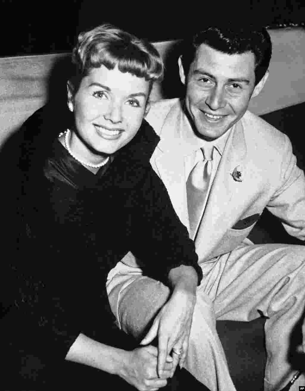  Eddie Fisher and his wife, Debbie Reynolds, attend the reception at the Prince of Wales Theater, London. Reynolds has likened their split to the Jennifer Aniston-Angelina Jolie-Brad Pitt triangle.