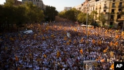 Warga melakukan pawai kemerdekaan sambil melambai-lambaikan bendera "estelada"yang melambangkan kemerdekaan Catalonia dalam aksi di kota Barcelona, Spanyol hari Minggu (11/9). 