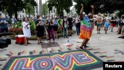 FILE - A woman reacts at a vigil following the police shooting of Jacob Blake, a Black man, in Kenosha, Wis., Aug. 28, 2020. 