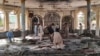 People view the damage inside of a mosque following a bombing in the provincial capital of Kunduz, northern Afghanistan, Oct. 8, 2021.