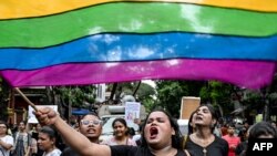 FILE - Activists and supporters of LGBTQ+ community wave the pride flag as they shout slogans in Kolkata, India, on Sept. 1, 2024. India's main opposition Congress party this week set up a new internal group to promote LGBTQ rights.