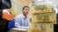 FILE - Stacks of 100,000 Vietnamese Dong notes ($4.70) are pictured as employees count money at a branch of the Bank for Investment and Development of Vietnam (BIDV) in Hanoi, Jan. 20, 2014. 