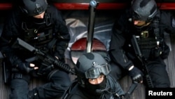 FILE - Members of French special police forces of Research and Intervention Brigade (BRI) take part in a mock terrorist attack inside the European Council building in Brussels, Belgium, Dec. 9, 2016. 