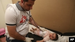 A Lebanese doctor checks a Syrian refugee at a mobile clinic for Doctors Without Borders, in the eastern Lebanese town of Marj near the border with Syria, May 20, 2013. 