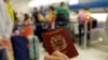 ARCHIVO - En esta foto tomada el miércoles 25 de junio de 2014, un pasajero sostiene su pasaporte venezolano mientras se prepara para viajar a Venezuela en el Aeropuerto Internacional de Miami.