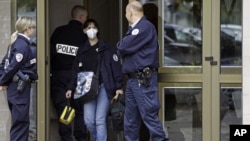 French police officers stand guard at the entrance of a building in Strasbourg, France, Saturday Oct. 6, 2012, where a suspect was shot dead after firing at police.