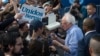 Democratic presidential candidate Sen. Bernie Sanders, I-Vt., signs autographs for Latino supporters at a campaign event at Valley High School in Santa Ana, Calif., Feb. 21, 2020.