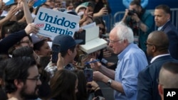 Democratic presidential candidate Sen. Bernie Sanders, I-Vt., signs autographs for Latino supporters at a campaign event at Valley High School in Santa Ana, Calif., Feb. 21, 2020.