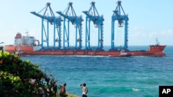 FILE - A vessel carries four cranes to be off-loaded at the port of Mombasa through the Kilindini channel, Kenya, on Aug. 7, 2023. Africa has seen significant growth in its port capacity in the past decade.