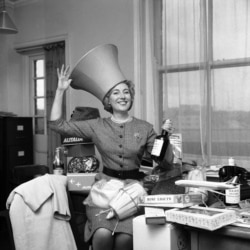 FILE - Singing star Vera Lynn tries on a lampshade in London, Nov. 30, 1961.