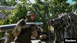 Українські військовослужбовці завантажують снаряд до малої реактивної системи залпового вогню «Партизан» на позиції поблизу лінії фронту в Запорізькій області, Україна, 13 липня 2023 року. REUTERS/Stringer