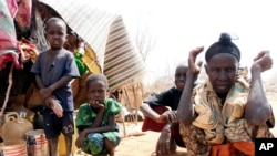FILE - Refugees sit outside in an open area as there is lack of tents at the Dollo Ado refugee camp, Ethiopia.