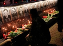A Ukrainian lights candles to commemorate those who died after the Chernobyl nuclear disaster, during a ceremony at the memorial to Chernobyl firefighters .