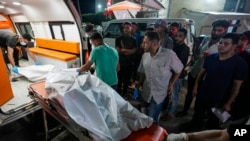 Palestinian medics move people killed in the Israeli bombardment of Al Zawayda in the central of Gaza Strip to the morgue of Al Aqsa hospital in Deir al Balah, Gaza Strip, early May 22, 2024. 
