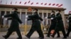 Chinese soldiers march past the Great Hall of the People during a preparatory session of the National People's Congress in Beijing, March 4, 2024.