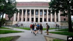 In this Aug. 13, 2019 file photo, students walk near the Widener Library in Harvard Yard at Harvard University in Cambridge, Mass. (AP Foto/Charles Krupa, archivo)