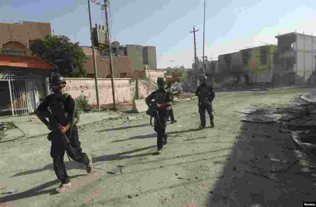 Members of the Iraqi Special Operations Forces take their positions during clashes with the Islamic State of Iraq and the Levant in Ramadi, Iraq, June 19, 2014.