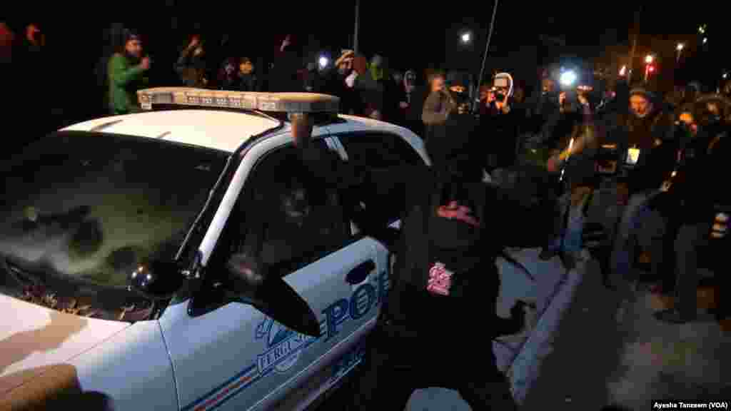 Des manifestants attaquent et renversent sur une voiture de police à l&#39;extérieur Ferguson City Hall, à Ferguson, Missouri, le 25 novembre 2014.
